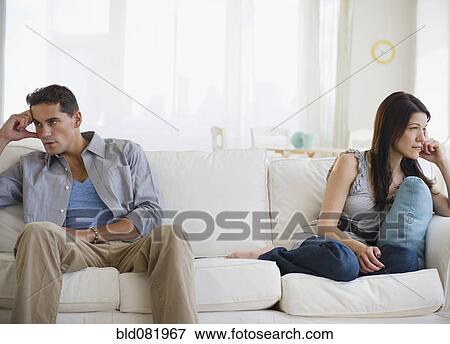 Stock Photo - Angry mixed race couple having argument on sofa. Fotosearch