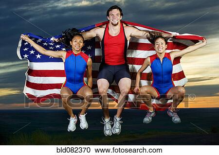 Athletes jumping in mid-air with American flag View Large Photo Image Stock Image - Athletes jumping in mid-air with American flag. Fotosearch