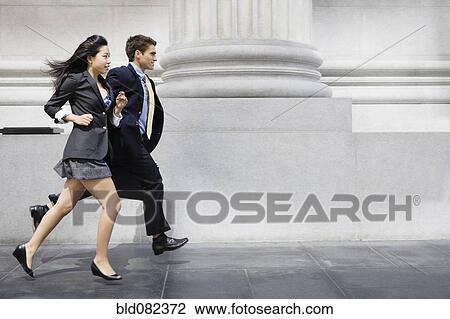 Stock Image - Business people running on sidewalk. Fotosearch