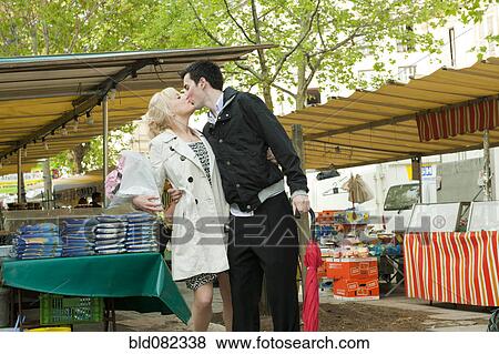 Caucasian couple kissing in market View Large Photo Image Stock Photo - Caucasian couple kissing in market. Fotosearch