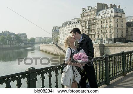 Caucasian couple kissing on bridge View Large Photo Image Stock Image - Caucasian couple kissing on bridge. Fotosearch