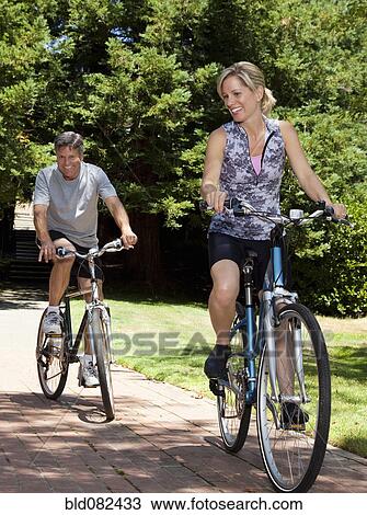 Caucasian couple riding bicycles View Large Photo Image Stock Image - Caucasian couple riding bicycles. Fotosearch