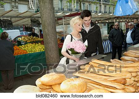 Stock Image - Caucasian couple shopping for bread at market. Fotosearch