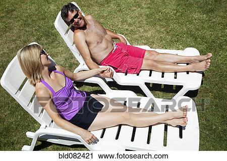 Caucasian couple sunbathing View Large Photo Image Stock Image - Caucasian couple sunbathing. Fotosearch