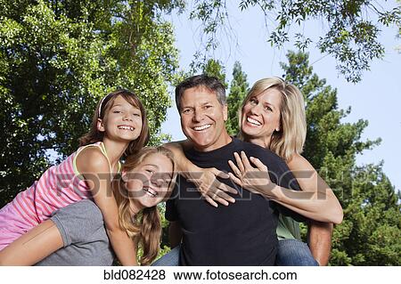 Stock Photo - Caucasian family giving piggyback rides. Fotosearch