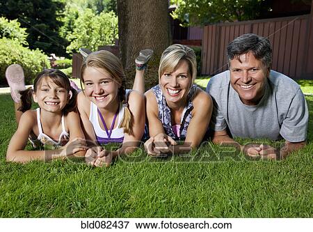 Caucasian family laying in grass View Large Photo Image Stock Photo - Caucasian family laying in grass. Fotosearch