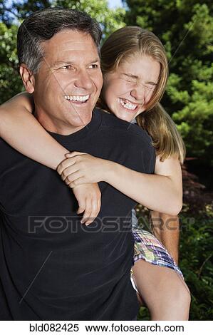 Stock Photography - Caucasian father giving daughter piggyback ride. Fotosearch