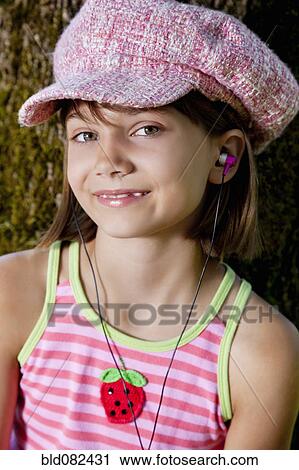 Stock Image - Caucasian girl listening to mp3 player. Fotosearch