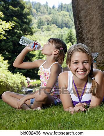 Stock Photograph - Caucasian girls relaxing in park. Fotosearch