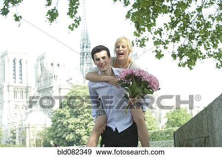 Caucasian man giving girlfriend piggyback ride near Notre Dame View Large Photo Image Stock Photo - Caucasian man giving girlfriend piggyback ride near Notre Dame. Fotosearch