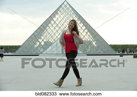 Stock Image - Caucasian woman walking at the Louvre. Fotosearch