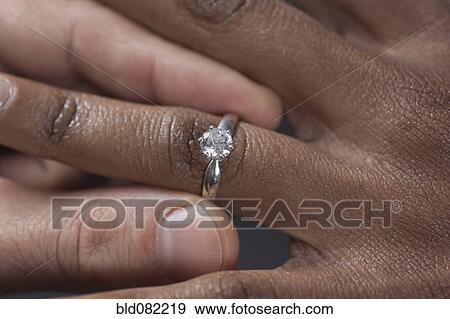 Stock Photo - Close up of man putting engagement ring on girlfriend. Fotosearch