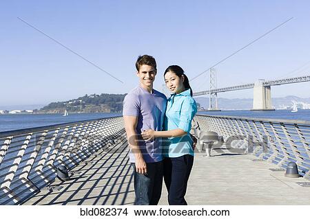 Couple hugging on pier at waterfront View Large Photo Image Picture - Couple hugging on pier at waterfront. Fotosearch