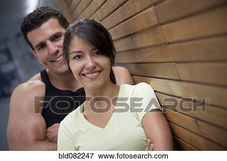 Stock Photo - Couple leaning against wooden wall. Fotosearch
