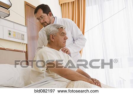 Doctor examining patient in hospital room View Large Photo Image Stock Photo - Doctor examining patient in hospital room. Fotosearch