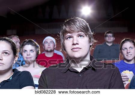Stock Photo - Friends watching movie in theater. Fotosearch