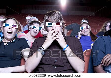 Friends watching movie in theater wearing 3D glasses View Large Photo Image Stock Photo - Friends watching movie in theater wearing 3D glasses. Fotosearch