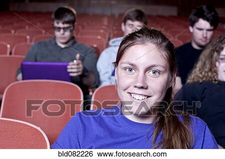 Stock Photograph - Friends watching movie in theater. Fotosearch