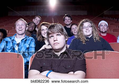 Stock Photograph - Friends watching movie in theater. Fotosearch