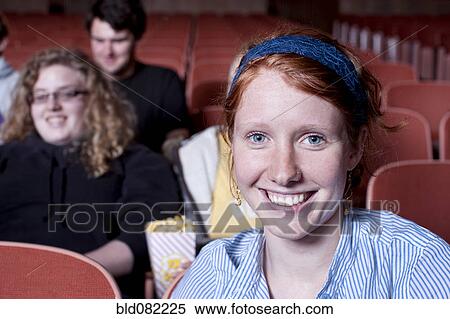 Stock Photography - Friends watching movie in theater. Fotosearch