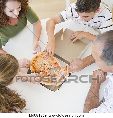 Stock Photo - Hispanic family eating pizza together. Fotosearch
