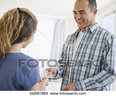 Hispanic father handing daughter money View Large Photo Image Picture - Hispanic father handing daughter money. Fotosearch