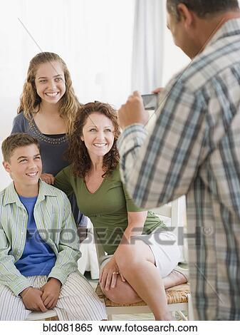 Hispanic man taking photograph of smiling family View Large Photo Image Stock Photography - Hispanic man taking photograph of smiling family. Fotosearch
