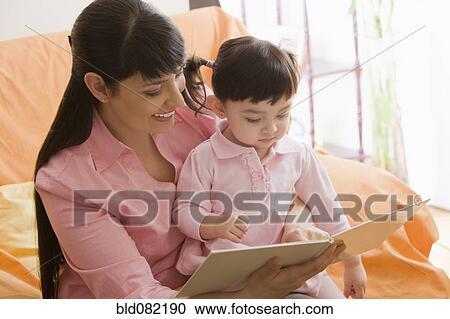 Hispanic mother reading storybook to daughter View Large Photo Image Stock Image - Hispanic mother reading storybook to daughter. Fotosearch