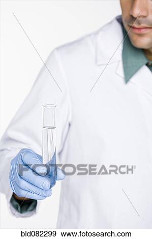 Stock Photo - Hispanic scientist holding test tube full of water. Fotosearch