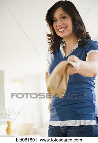 Hispanic woman holding out paper bag View Large Photo Image Stock Image - Hispanic woman holding out paper bag. Fotosearch