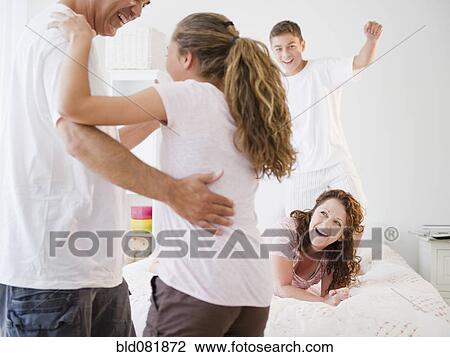Stock Image - Laughing Hispanic family playing together. Fotosearch