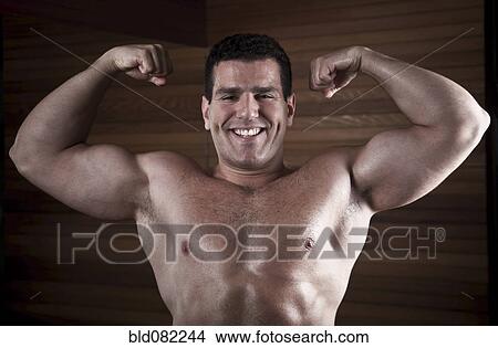 Picture - Middle Eastern man flexing biceps. Fotosearch