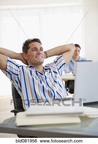 Mixed race businessman leaning back in chair at desk View Large Photo Image Stock Photograph - Mixed race businessman leaning back in chair at desk. Fotosearch