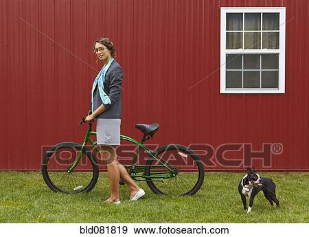 Mixed race businesswoman standing with bicycle and dog View Large Photo Image Stock Photo - Mixed race businesswoman standing with bicycle and dog. Fotosearch