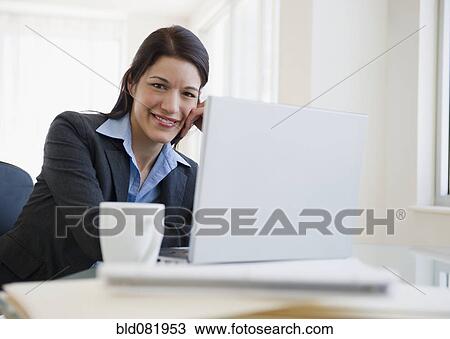 Mixed race businesswoman using laptop in office View Large Photo Image Stock Image - Mixed race businesswoman using laptop in office. Fotosearch