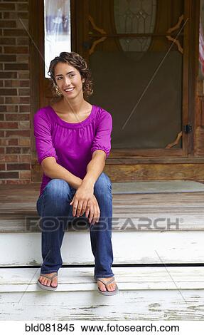 Stock Photography - Mixed race woman sitting on front stoop. Fotosearch