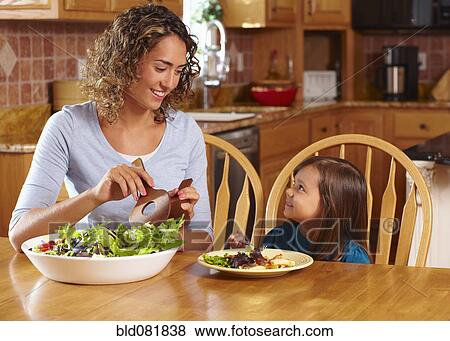 Mother serving daughter salad View Large Photo Image Stock Photo - Mother serving daughter salad. Fotosearch
