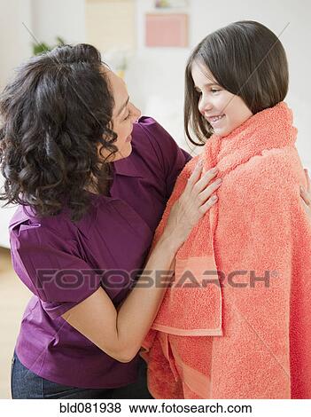 Stock Photo - Mother wrapping daughter in towel. Fotosearch