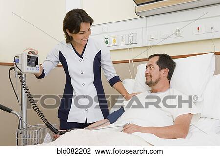Nurse taking patient's blood pressure in hospital room View Large Photo Image Stock Image - Nurse taking patient's blood pressure in hospital room. Fotosearch