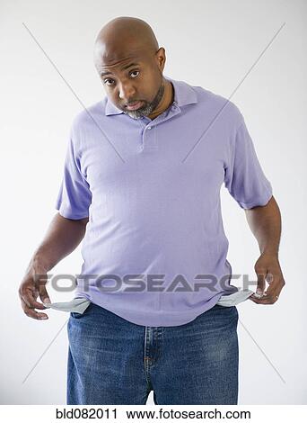 Stock Image - Sad African American holding out empty pockets. Fotosearch