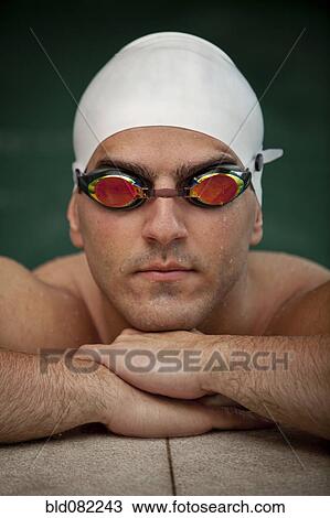 Stock Image - Serious Middle Eastern swimmer in swim cap and goggles. Fotosearch