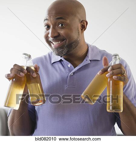 Smiling African American man holding beer bottles View Large Photo Image Stock Image - Smiling African American man holding beer bottles. Fotosearch