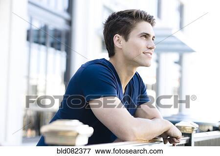Smiling Caucasian man leaning on railing View Large Photo Image Stock Photo - Smiling Caucasian man leaning on railing. Fotosearch