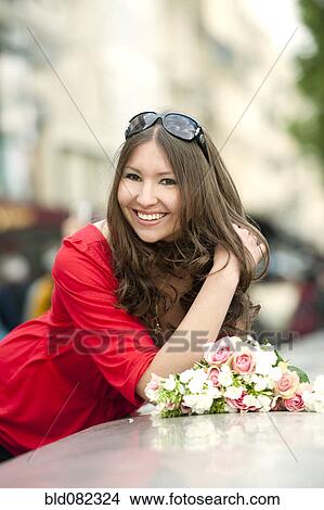 Picture - Smiling Caucasian woman holding bouquet. Fotosearch