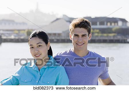 Smiling couple at waterfront View Large Photo Image Stock Image - Smiling couple at waterfront. Fotosearch