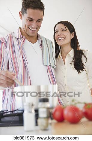 Smiling couple cooking dinner together View Large Photo Image Stock Image - Smiling couple cooking dinner together. Fotosearch