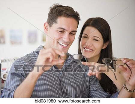 Smiling couple shopping for eyeglasses together View Large Photo Image Stock Image - Smiling couple shopping for eyeglasses together. Fotosearch