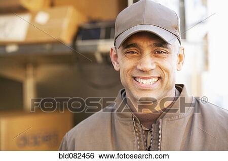 Stock Photograph - Smiling Hispanic delivery man. Fotosearch