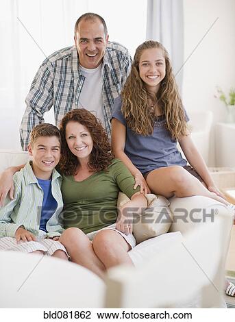 Smiling Hispanic family sitting on sofa together View Large Photo Image Stock Image - Smiling Hispanic family sitting on sofa together. Fotosearch