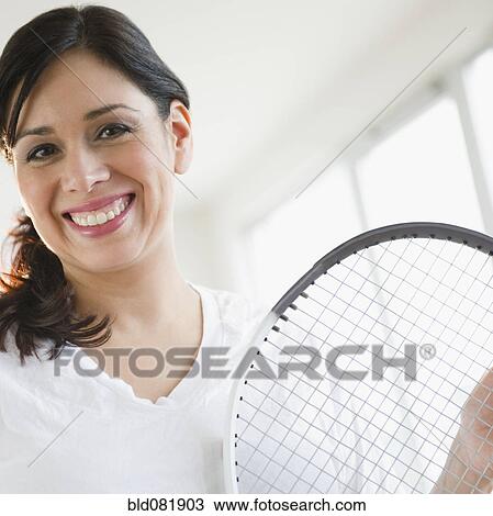 Smiling Hispanic woman holding tennis racquet View Large Photo Image Stock Image - Smiling Hispanic woman holding tennis racquet. Fotosearch